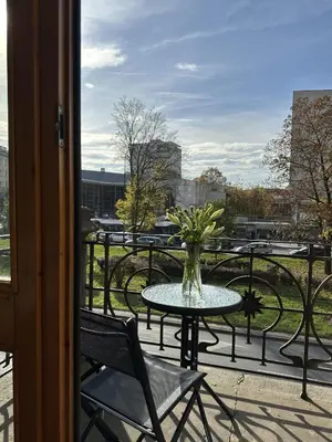 a vase of flowers sitting on a table on a balcony at Native Apartments Krasińskiego 21 in Kraków