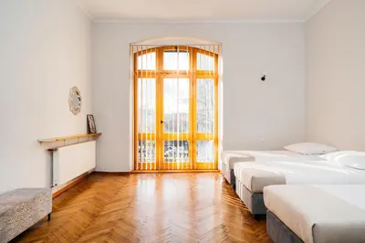 a room with three beds and a window at Native Apartments Krasińskiego 21 in Kraków