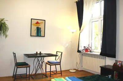 a living room with a table and chairs and a window at Bona Studio, City Center, WiFi in Kraków