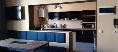 a kitchen with a sink and a wooden table at Rembrandt Hostel in Kraków