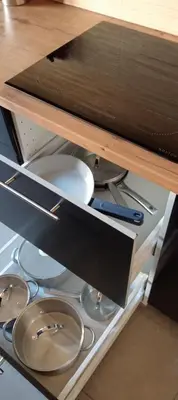 a drawer in a cabinet with plates and utensils at Rembrandt Hostel in Kraków