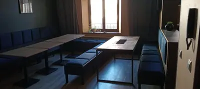 a restaurant with tables and benches and a window at Rembrandt Hostel in Kraków