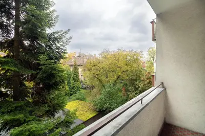 a balcony with a view of a garden at Malila Premium Apartments Brodowicza 5 in Kraków
