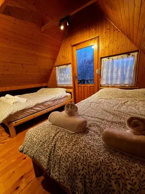 a bedroom with two beds in a wooden cabin at Świerkowa Chata in Targanice