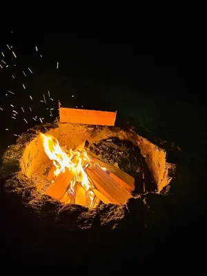 a fire is burning in a fire pit at night at Świerkowa Chata in Targanice