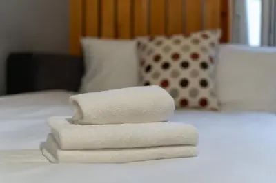 a pile of towels sitting on top of a bed at Dębniki Comfort Studio by BookingHost in Kraków