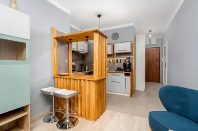 a kitchen with a wooden counter and a blue couch at Dębniki Comfort Studio by BookingHost in Kraków