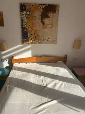 a bedroom with a bed with a painting on the wall at Ruczaj Cozy Room in Kraków