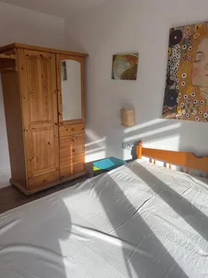 a bedroom with a bed and a wooden cabinet at Ruczaj Cozy Room in Kraków
