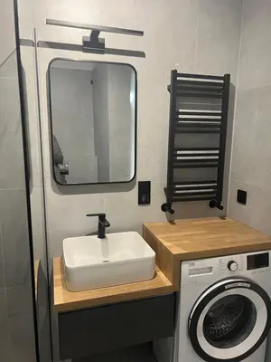 a bathroom with a sink and a washing machine at Ruczaj Cozy Room in Kraków