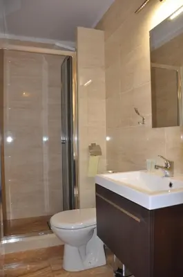 a bathroom with a toilet and a sink and a shower at Hotel Mis in Bochnia