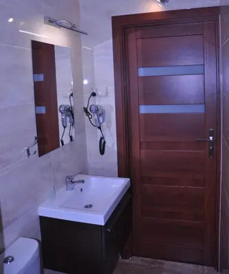 a bathroom with a sink and a wooden door at Hotel Mis in Bochnia
