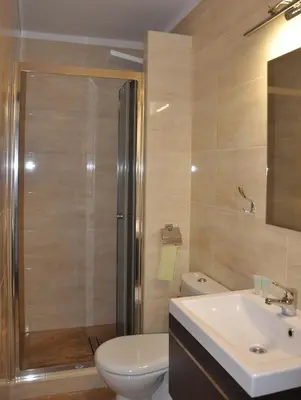 a bathroom with a shower and a toilet and a sink at Hotel Mis in Bochnia