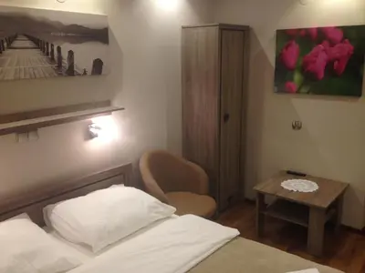 a small bedroom with a bed and a table at Hotel Mis in Bochnia