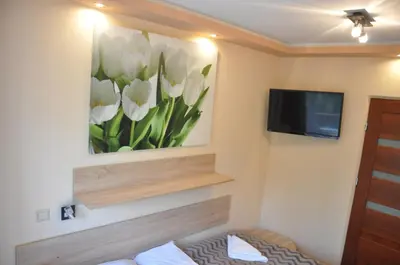 a room with a painting of white tulips on the wall at Hotel Mis in Bochnia
