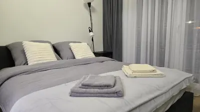a bed with two towels on top of it at Apartamenty Żurawia 1- Piętro 2 in Kraków
