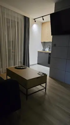a living room with a coffee table and a kitchen at Apartamenty Żurawia 1- Piętro 2 in Kraków
