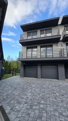 a house with two garage doors and a patio at Apartamenty Żurawia 1- Piętro 2 in Kraków