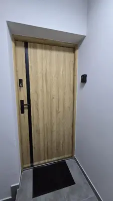 a large wooden door in a room with a floor at Apartamenty Żurawia 1- Piętro 2 in Kraków