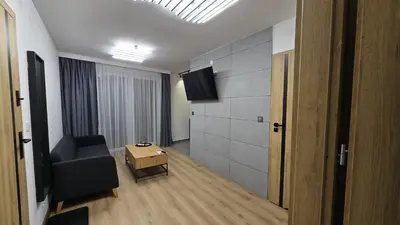a living room with a couch and a tv on a wall at Apartamenty Żurawia 1- Piętro 2 in Kraków