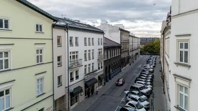 a city street with parked cars and buildings at Bocheńska Modern Apartment by BookingHost in Kraków