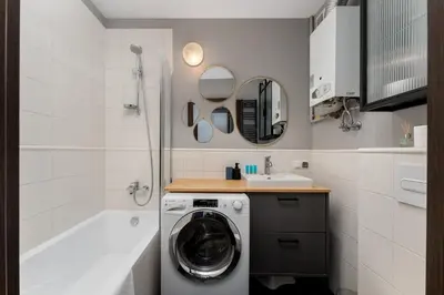 a bathroom with a washing machine and a sink at Bocheńska Modern Apartment by BookingHost in Kraków
