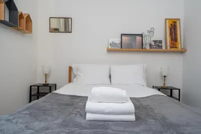 a bedroom with a white bed with two night stands at Bocheńska Modern Apartment by BookingHost in Kraków