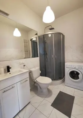 a bathroom with a toilet and a shower and a washing machine at Krakow City Stay - City Vibes, Historic Charm in Kraków