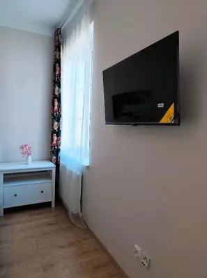 a flat screen tv on a wall in a room at Krakow City Stay - City Vibes, Historic Charm in Kraków
