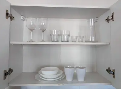 a shelf with wine glasses and plates and bowls at Krakow City Stay - City Vibes, Historic Charm in Kraków