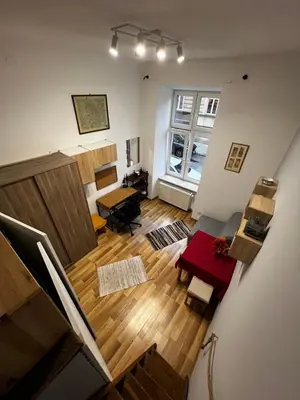 an overhead view of a living room with wooden floors at small studio flat with loft in Kraków