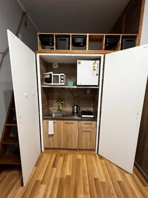a small kitchen with a stove and a microwave at small studio flat with loft in Kraków