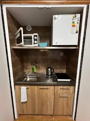 a small kitchen with a sink and a microwave at small studio flat with loft in Kraków