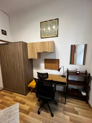 a room with a desk and a table and a piano at small studio flat with loft in Kraków