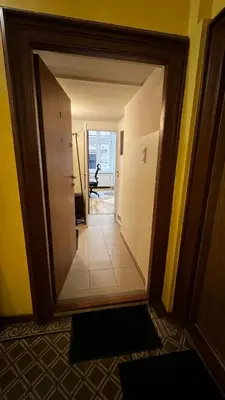 a hallway with a mirror in a room at small studio flat with loft in Kraków