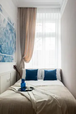 a bed sitting in a room with a window at Colora Apartments by MB Apartments in Kraków