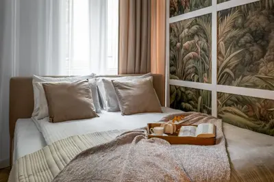 a bed with a tray with a book on it at Colora Apartments by MB Apartments in Kraków