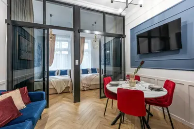 a living room with a table and chairs and a couch at Colora Apartments by MB Apartments in Kraków