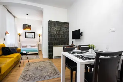 a living room with a table and a yellow couch at Apartament Tenczyńska in Kraków