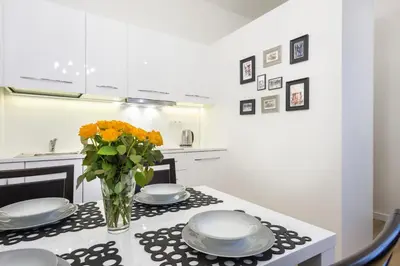 a kitchen with a table with plates and a vase of flowers at Apartament Tenczyńska in Kraków