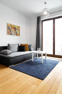 a living room with a couch and a table at Househost Apartment Plac Na Groblach 5 in Kraków