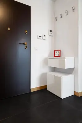 a room with a black door and a white shelf at Househost Apartment Plac Na Groblach 5 in Kraków