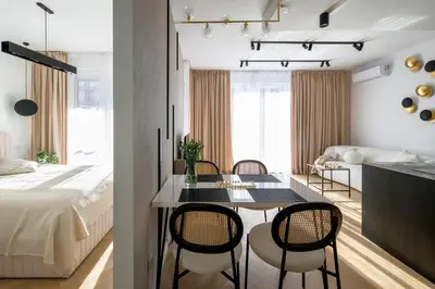 a bedroom and a living room with a table and chairs at Fancy 2bdr Golden Dots apartment in city centre in Kraków