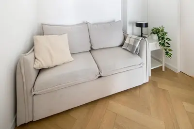 a couch with two pillows on it in a living room at Fancy 2bdr Golden Dots apartment in city centre in Kraków