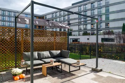 a couch on a patio in front of a building at Fancy 2bdr Golden Dots apartment in city centre in Kraków