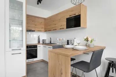 a kitchen with a wooden counter top and white appliances at Aleja Kijowska Kraków Modern Apartment with Balcony and Parking by Noclegi Renters in Kraków