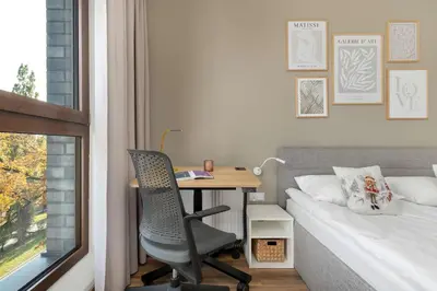 a bedroom with a desk and a bed and a desk and a chair at Aleja Kijowska Kraków Modern Apartment with Balcony and Parking by Noclegi Renters in Kraków