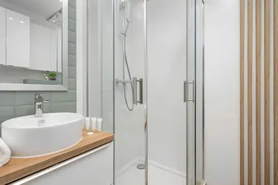 a bathroom with a sink and a shower at Aleja Kijowska Kraków Modern Apartment with Balcony and Parking by Noclegi Renters in Kraków