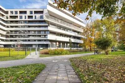 a building with a sidewalk in front of a building at Aleja Kijowska Kraków Modern Apartment with Balcony and Parking by Noclegi Renters in Kraków