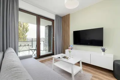 a living room with a couch and a tv at Aleja Kijowska Kraków Modern Apartment with Balcony and Parking by Noclegi Renters in Kraków